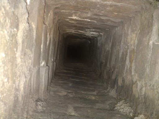 A dark, rectangular stone tunnel extending into the distance.